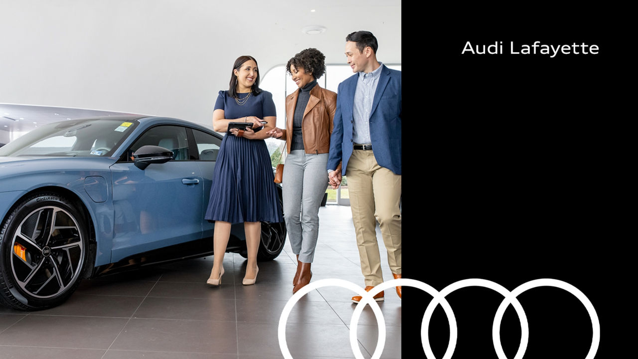 Audi Sale Specialist walking through the showroom with a couple.